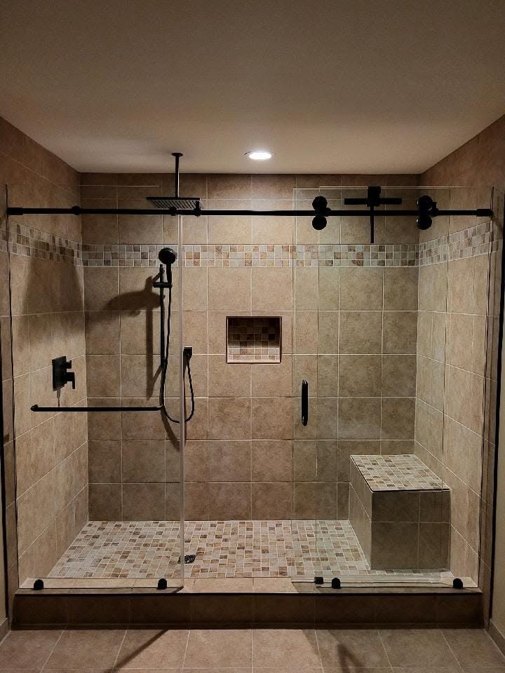 Large tiled master shower with glass doors, rain head, niche and built-in bench