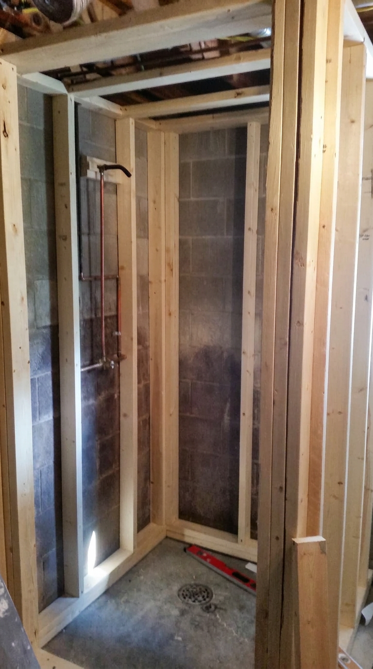 Wood framing and plumbing prepared for a new shower enclosure