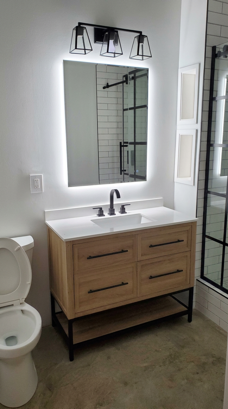 Installed bathroom vanity, lighted mirror, fixtures and shower enclosure