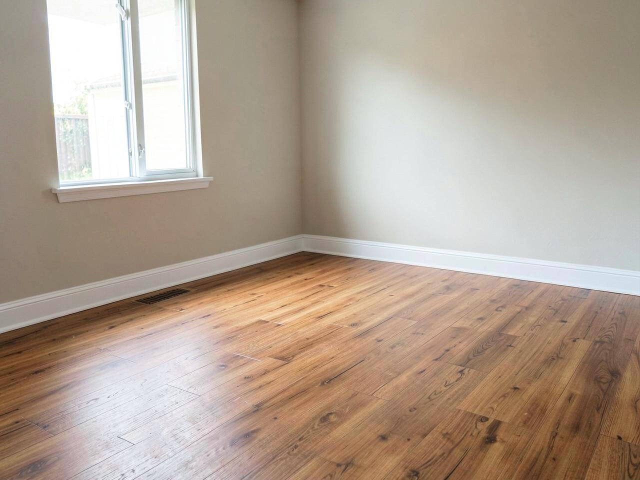 Wood-look plank flooring installed with new white baseboards